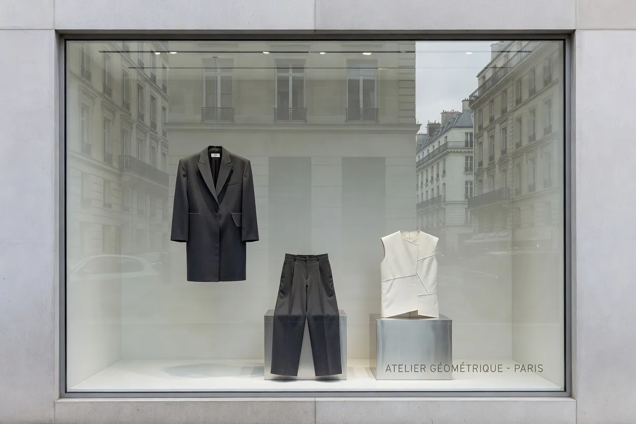 Vitrine de concept store parisien avec vêtements et objets de design aux lignes épurées